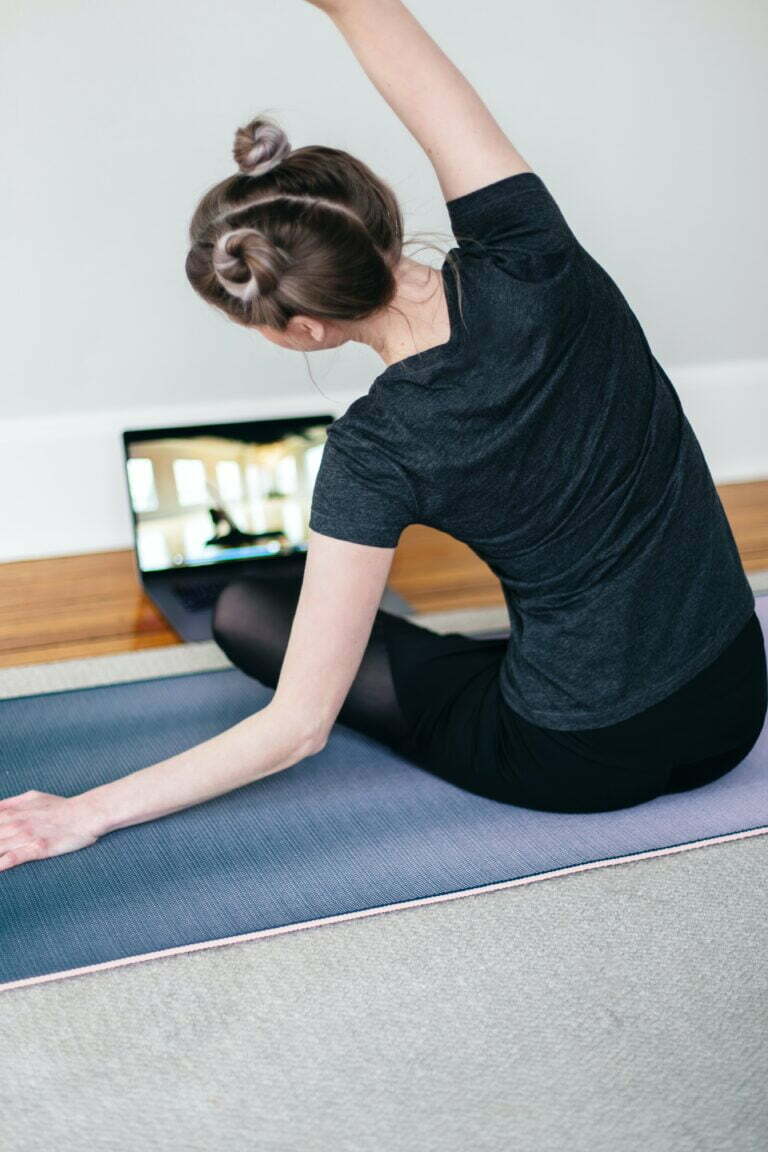 woman on yoga mat at computer kari-shea-qa1wvrlWCio-unsplash